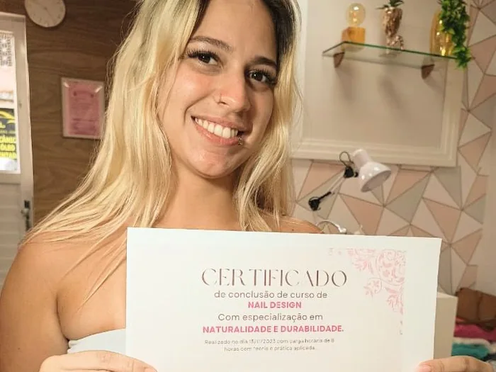 Aluna exibindo certificado do curso de unhas de gel com molde F1, ministrado por Marcela Cupello